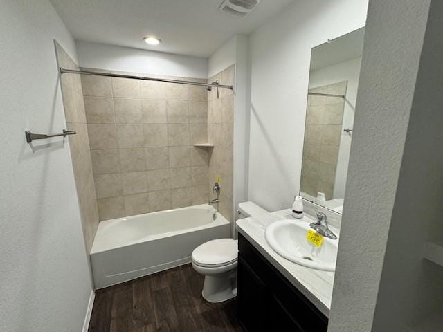 full bathroom with tiled shower / bath combo, wood-type flooring, vanity, and toilet