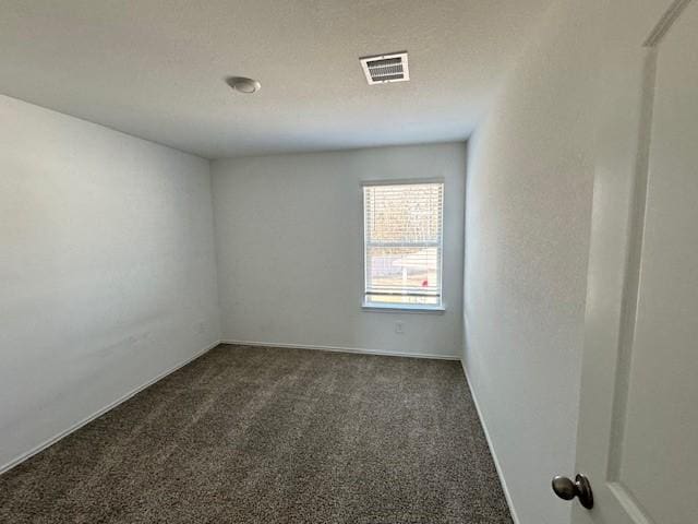 carpeted spare room with a textured ceiling