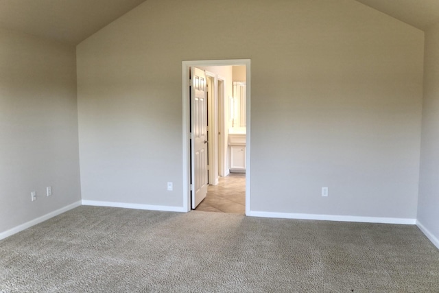 carpeted spare room featuring vaulted ceiling