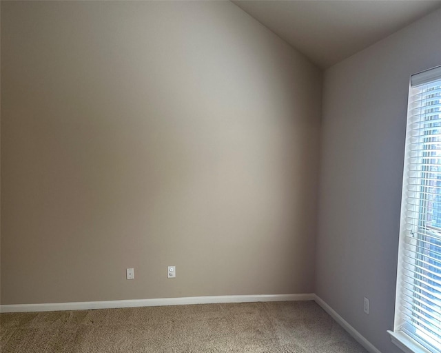 unfurnished room featuring lofted ceiling and carpet floors