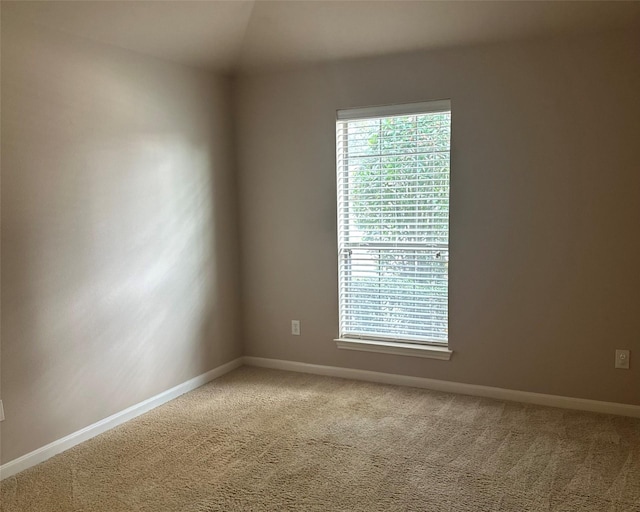 unfurnished room with vaulted ceiling and carpet