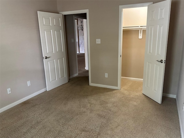 unfurnished bedroom with light carpet, a spacious closet, and a closet