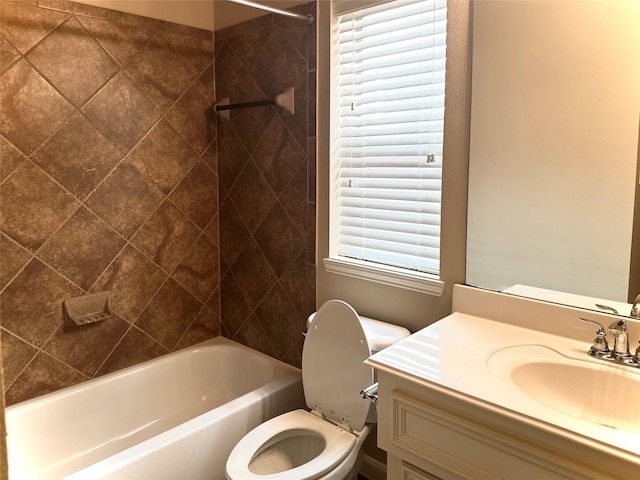 full bathroom featuring tiled shower / bath combo, vanity, and toilet