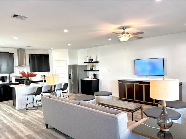 living room with ceiling fan, sink, and light hardwood / wood-style flooring