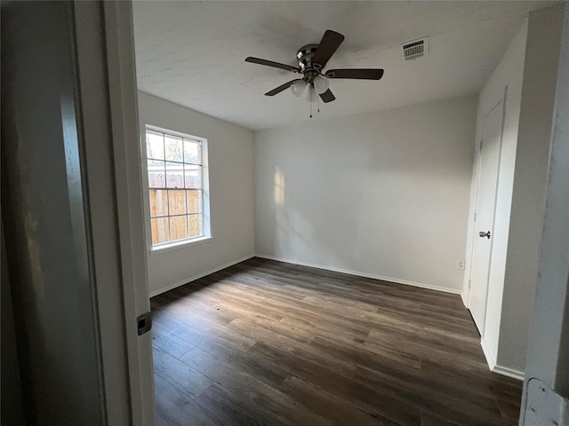 spare room with dark wood-type flooring and ceiling fan