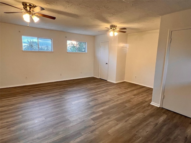 empty room featuring ceiling fan, dark hardwood / wood-style floors, and a textured ceiling