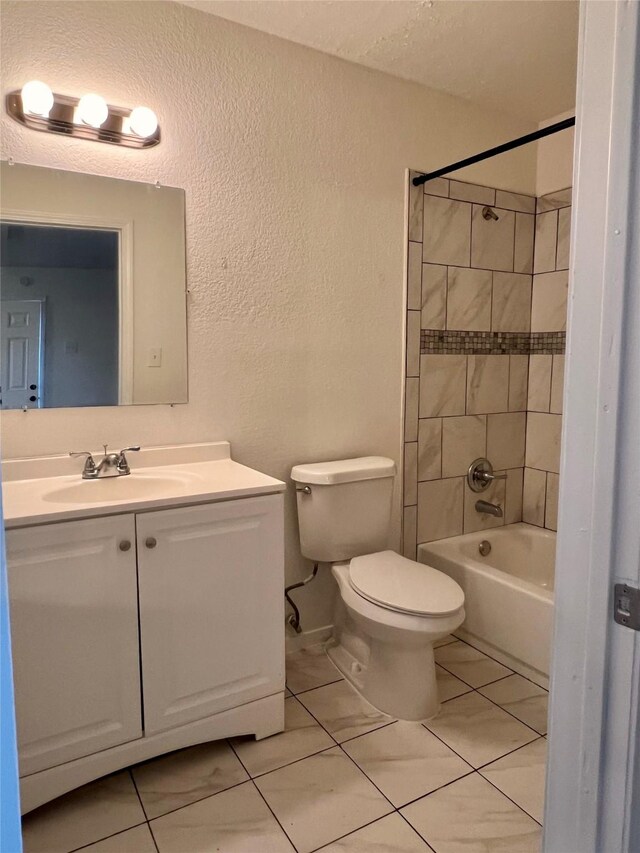 full bathroom with vanity, tiled shower / bath combo, and toilet