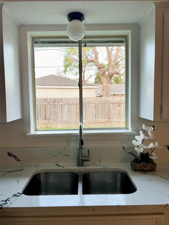 kitchen featuring sink and light stone countertops