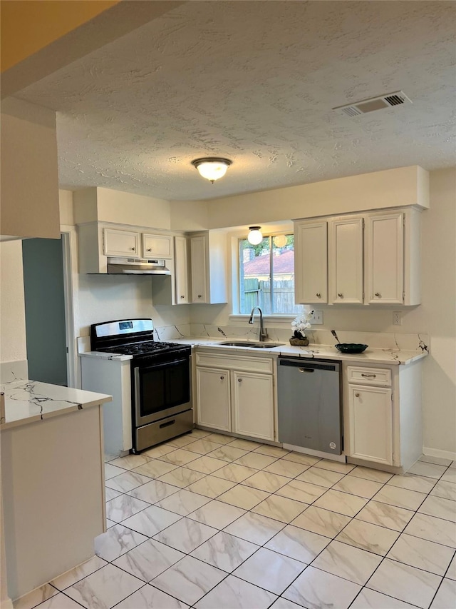 kitchen featuring sink, a textured ceiling, white cabinets, and appliances with stainless steel finishes