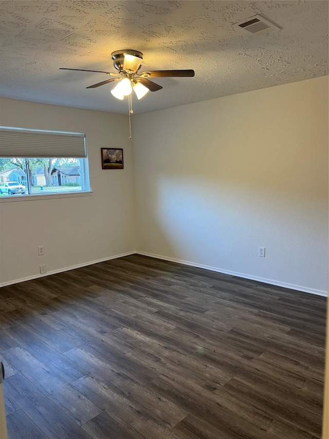 spare room with ceiling fan, dark hardwood / wood-style flooring, and a textured ceiling