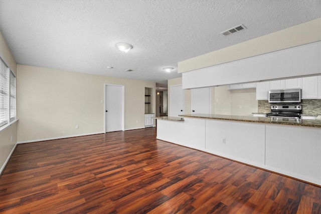 unfurnished living room featuring dark hardwood / wood-style floors and a textured ceiling