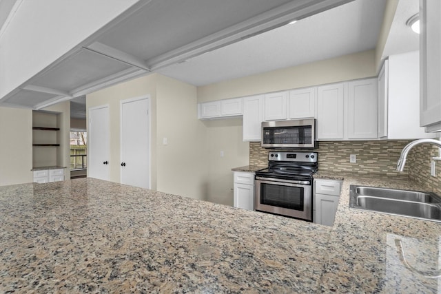 kitchen with sink, light stone counters, appliances with stainless steel finishes, decorative backsplash, and white cabinets