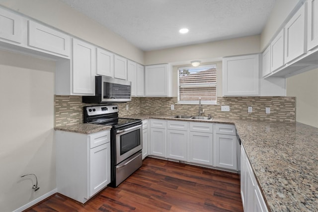 kitchen featuring dark wood-type flooring, sink, light stone counters, stainless steel appliances, and white cabinets