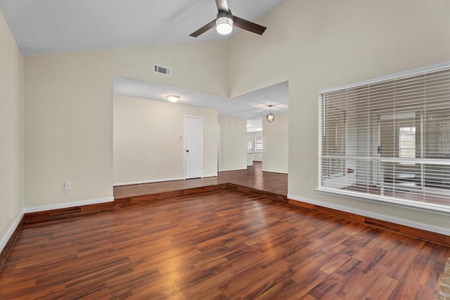 empty room with high vaulted ceiling, dark hardwood / wood-style floors, and ceiling fan