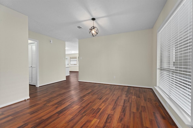 empty room featuring dark hardwood / wood-style flooring and a textured ceiling