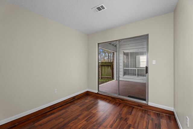 unfurnished room with dark hardwood / wood-style floors and a textured ceiling