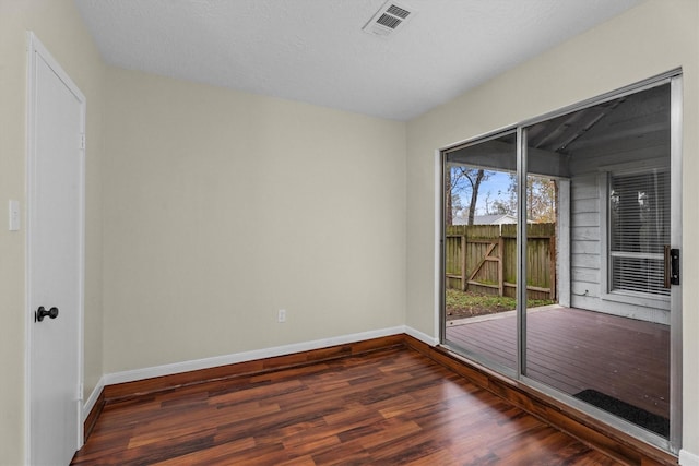 spare room with dark hardwood / wood-style flooring and a textured ceiling