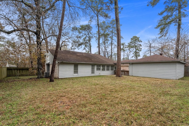 rear view of property featuring cooling unit and a lawn