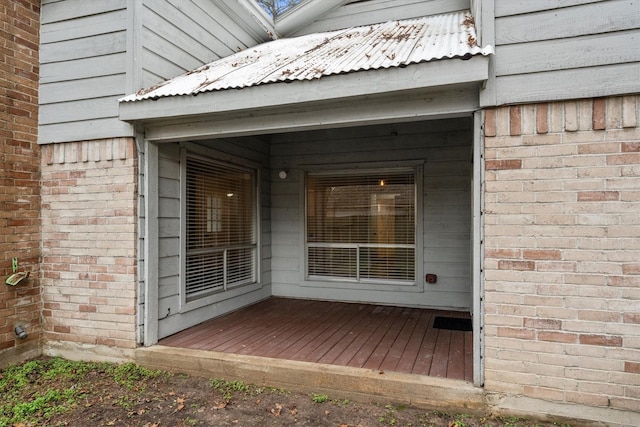 view of exterior entry featuring a wooden deck