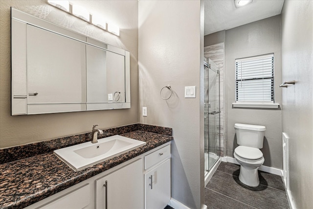 bathroom with vanity, an enclosed shower, and toilet
