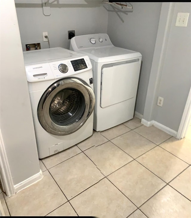 washroom featuring separate washer and dryer and light tile patterned floors