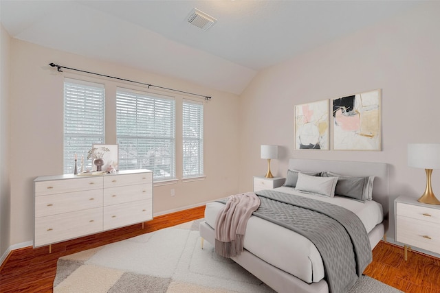 bedroom with vaulted ceiling and light wood-type flooring