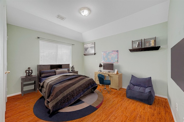 bedroom with hardwood / wood-style floors and vaulted ceiling