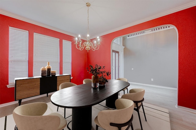 dining space featuring a notable chandelier, crown molding, and light wood-type flooring