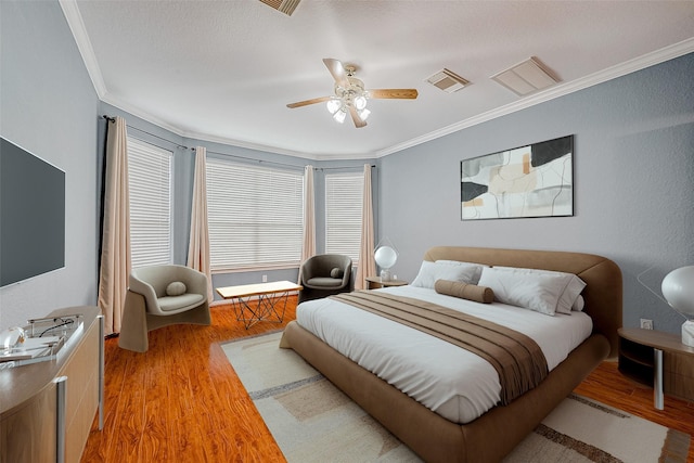 bedroom featuring ceiling fan, ornamental molding, and hardwood / wood-style floors