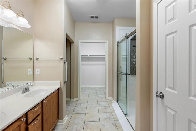 bathroom with vanity, an enclosed shower, and tile patterned flooring