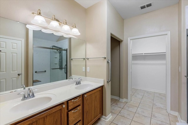 bathroom with walk in shower, vanity, and tile patterned flooring