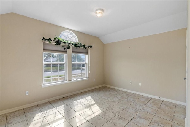 tiled empty room with lofted ceiling