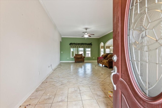 entryway with light tile patterned floors, ornamental molding, and ceiling fan