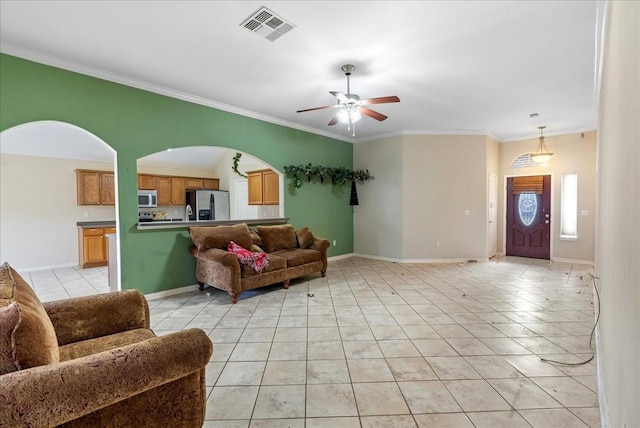 living room with light tile patterned flooring, ceiling fan, and ornamental molding