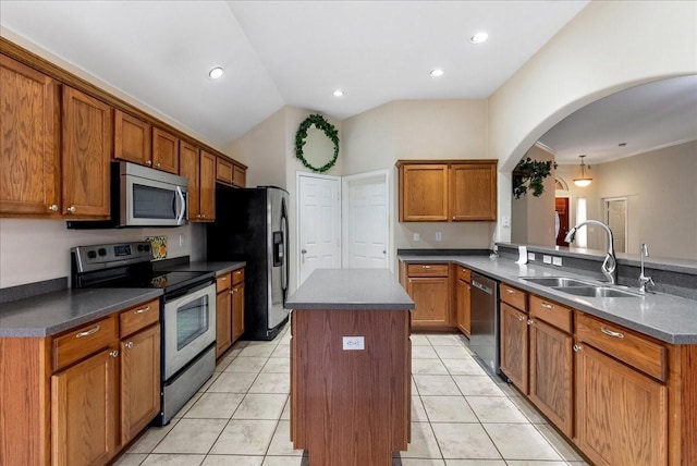 kitchen featuring appliances with stainless steel finishes, sink, a center island, light tile patterned floors, and kitchen peninsula