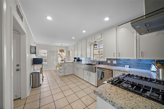 kitchen with sink, white cabinetry, light stone counters, hanging light fixtures, and dishwasher