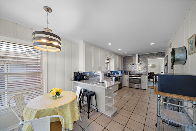 kitchen featuring white cabinetry, light tile patterned floors, stainless steel range, kitchen peninsula, and wall chimney range hood