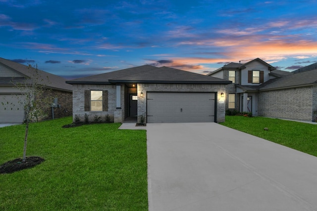 prairie-style house featuring a garage and a yard