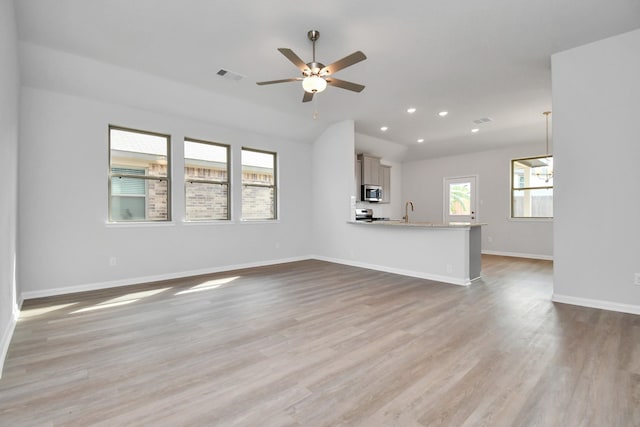 unfurnished living room featuring ceiling fan and light hardwood / wood-style floors