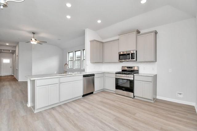 kitchen featuring sink, vaulted ceiling, stainless steel appliances, and gray cabinets