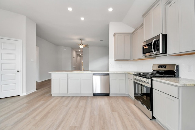 kitchen with sink, ceiling fan, stainless steel appliances, kitchen peninsula, and light wood-type flooring