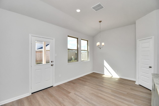 interior space featuring a notable chandelier, vaulted ceiling, and light wood-type flooring