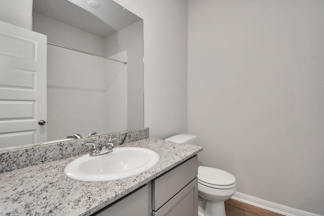 bathroom with vanity, wood-type flooring, walk in shower, and toilet