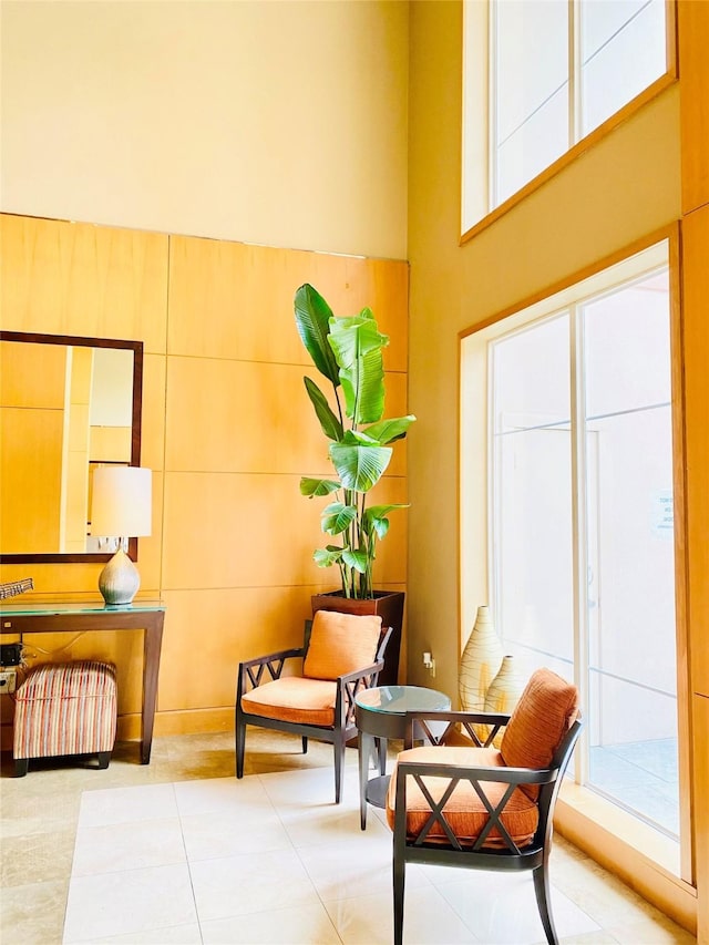 living area featuring tile patterned flooring and a towering ceiling