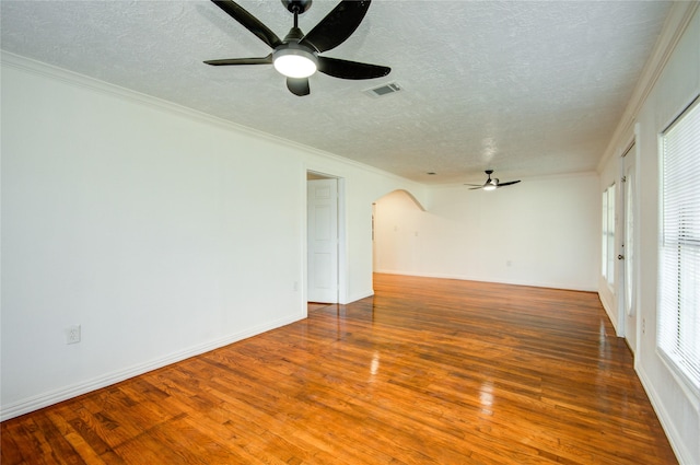 spare room featuring hardwood / wood-style flooring, ornamental molding, a textured ceiling, and ceiling fan