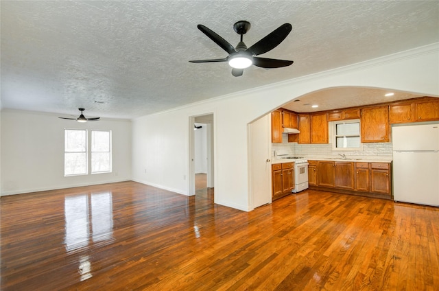 kitchen with sink, ornamental molding, dark hardwood / wood-style floors, white appliances, and decorative backsplash