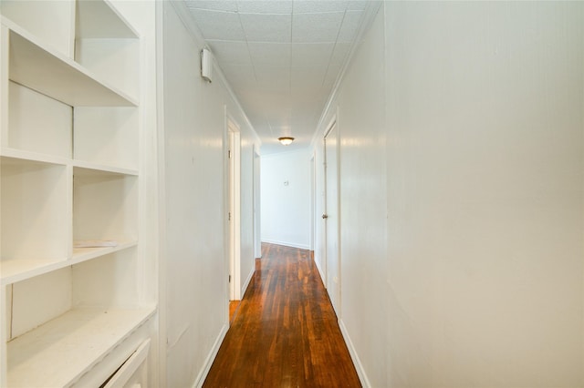 corridor featuring dark hardwood / wood-style floors and built in shelves