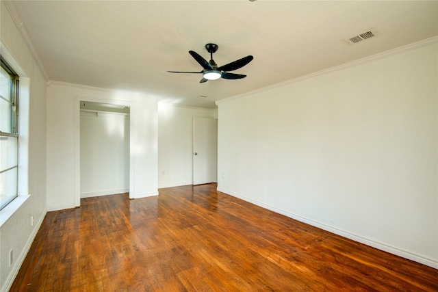 unfurnished bedroom featuring a closet, crown molding, and dark hardwood / wood-style floors