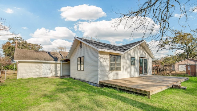 back of house with a storage shed, a lawn, and a deck