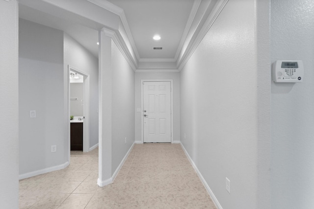 hallway with ornamental molding and light tile patterned floors